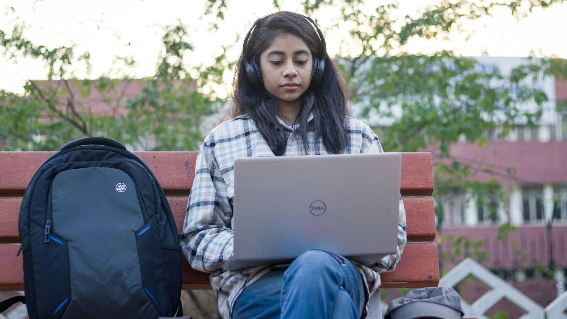 Young woman sitting on a bench using a laptop computer