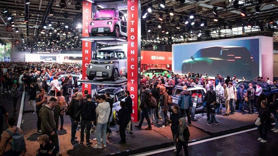 Crowds and cars at the Paris Motor Show entrance hall