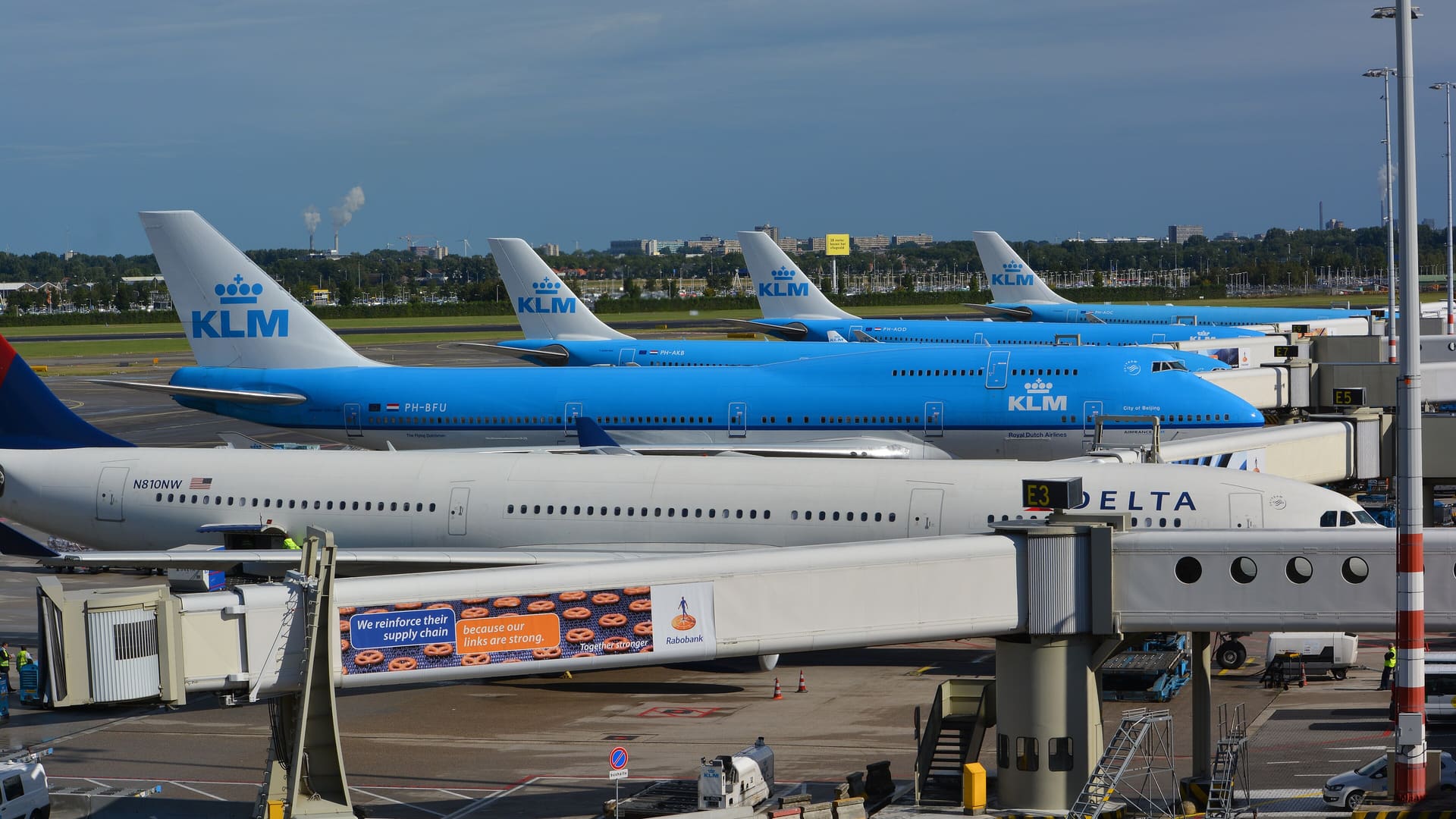 Four KLM long-haul aircraft parked at Amsterdam Schiphol Airport.
