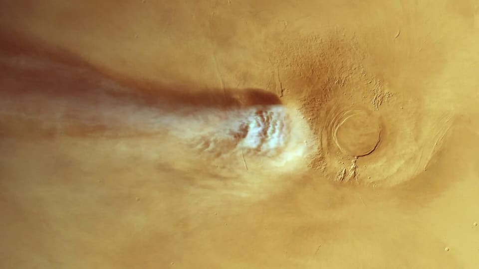Arsia Mons volcano on Mars with elongated cloud formation stretching across the Martian surface