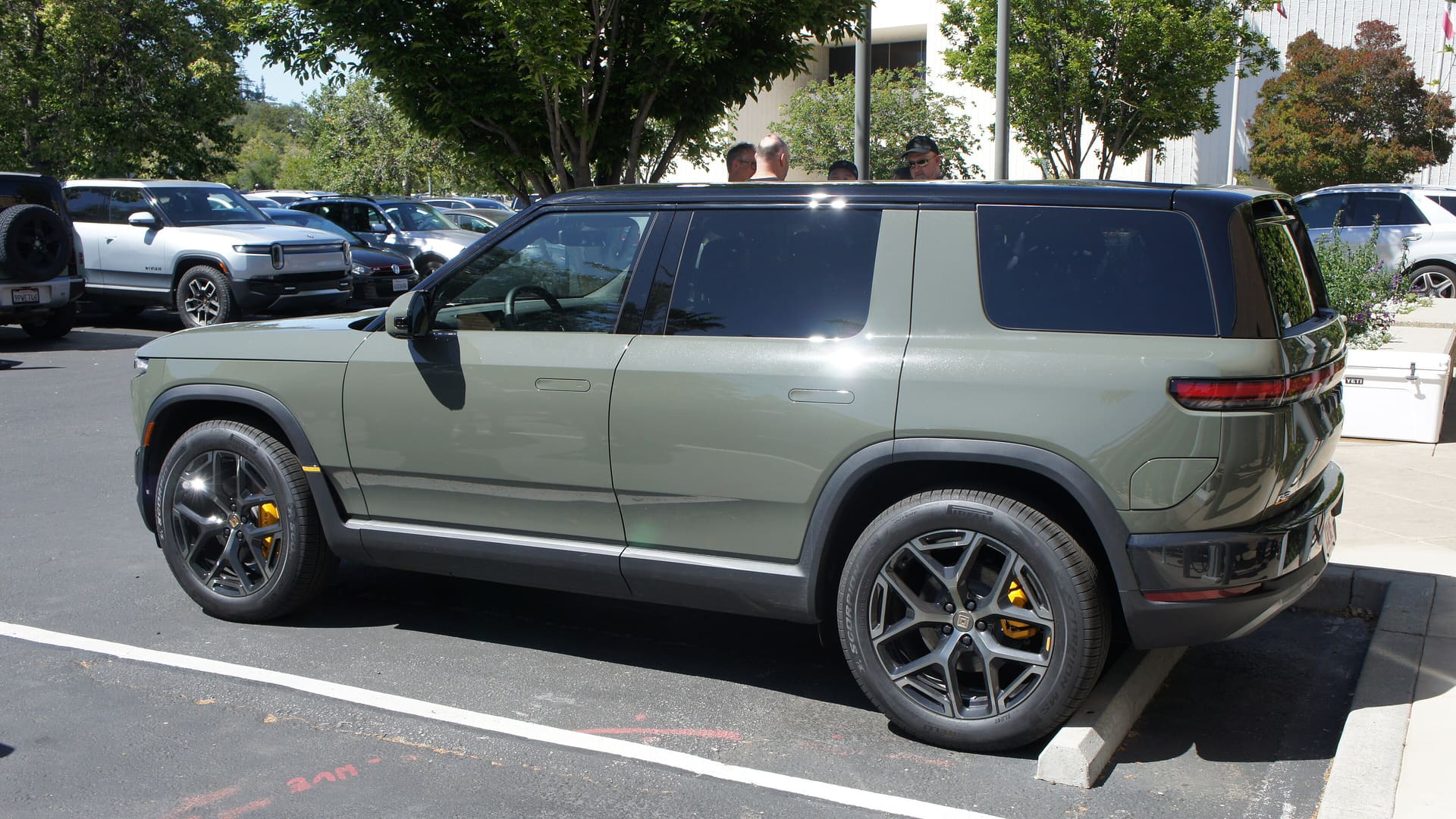 Rivian R2 electric SUV in Launch Green, seen from the side and rear