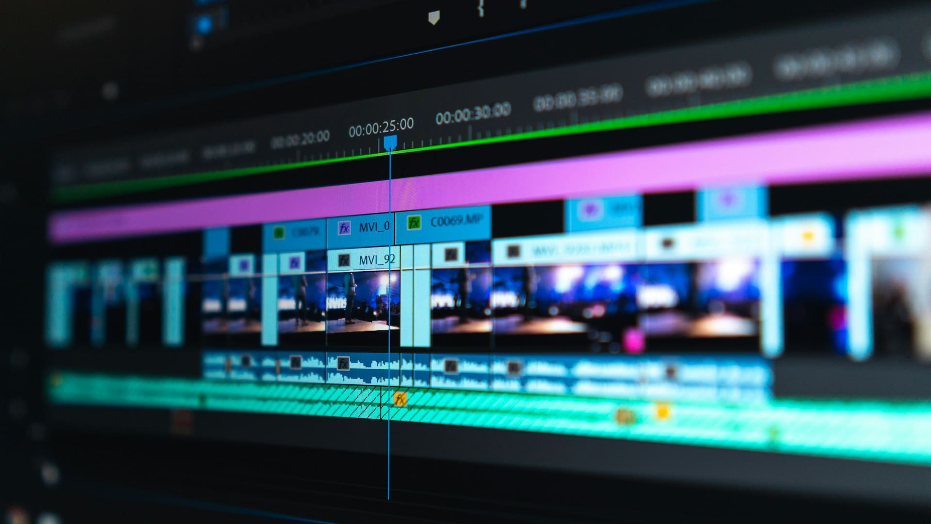 Video editing timeline with blue and purple clips displayed on dark screen