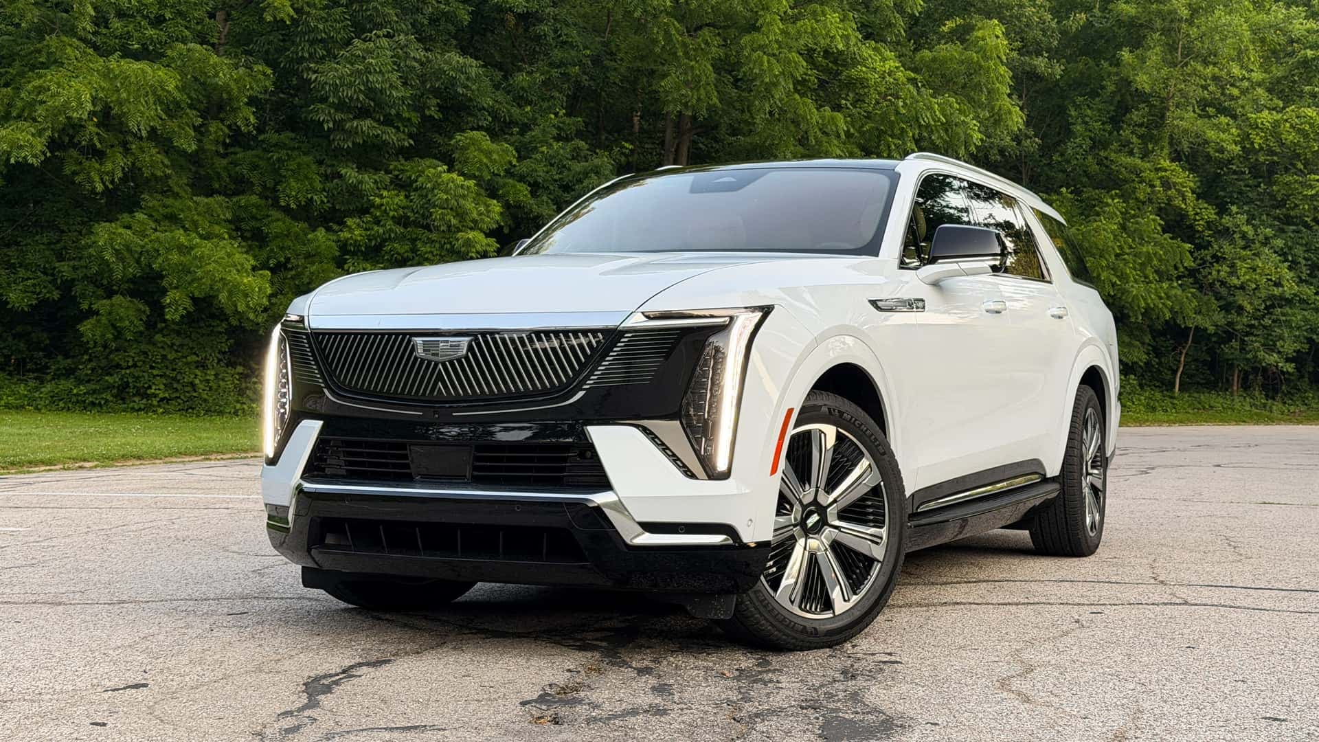 A Cadillac Escalade IQ electric SUV connected to a charger