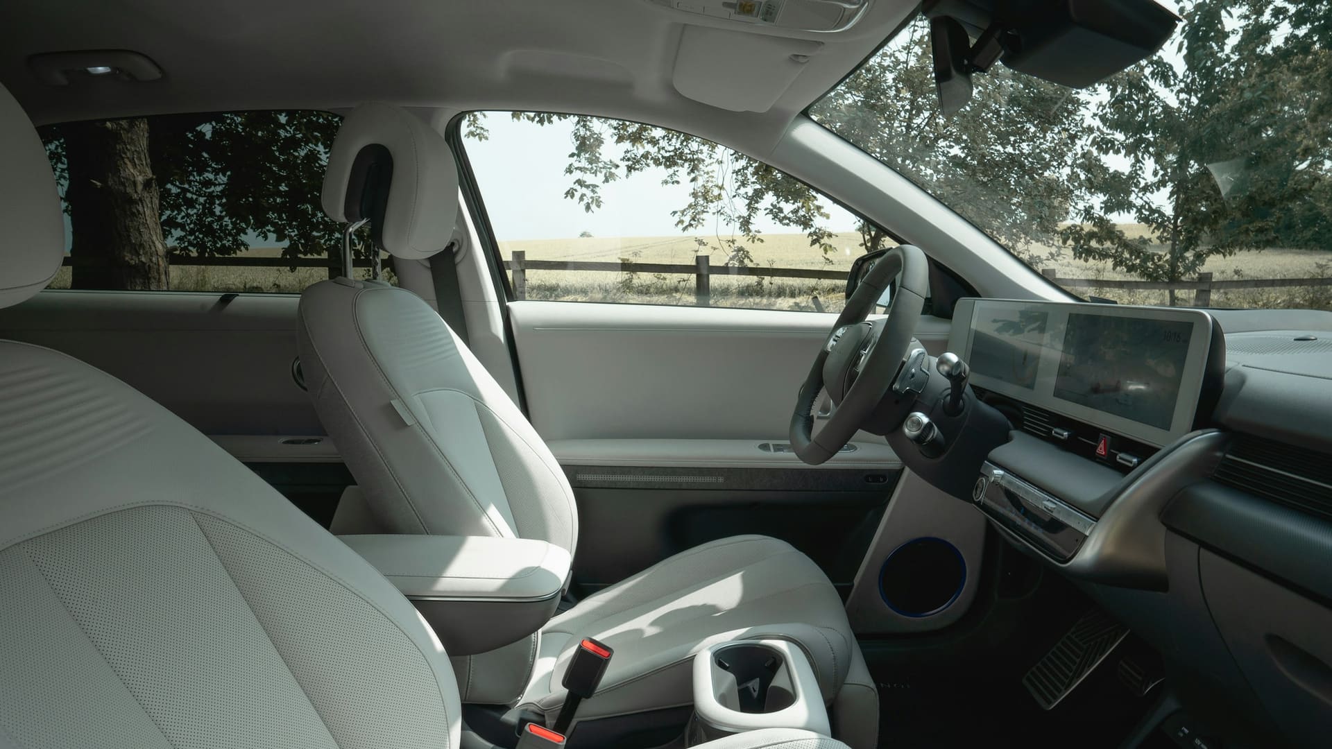 Interior of a Hyundai Ioniq 5 with white seats, steering wheel and dashboard