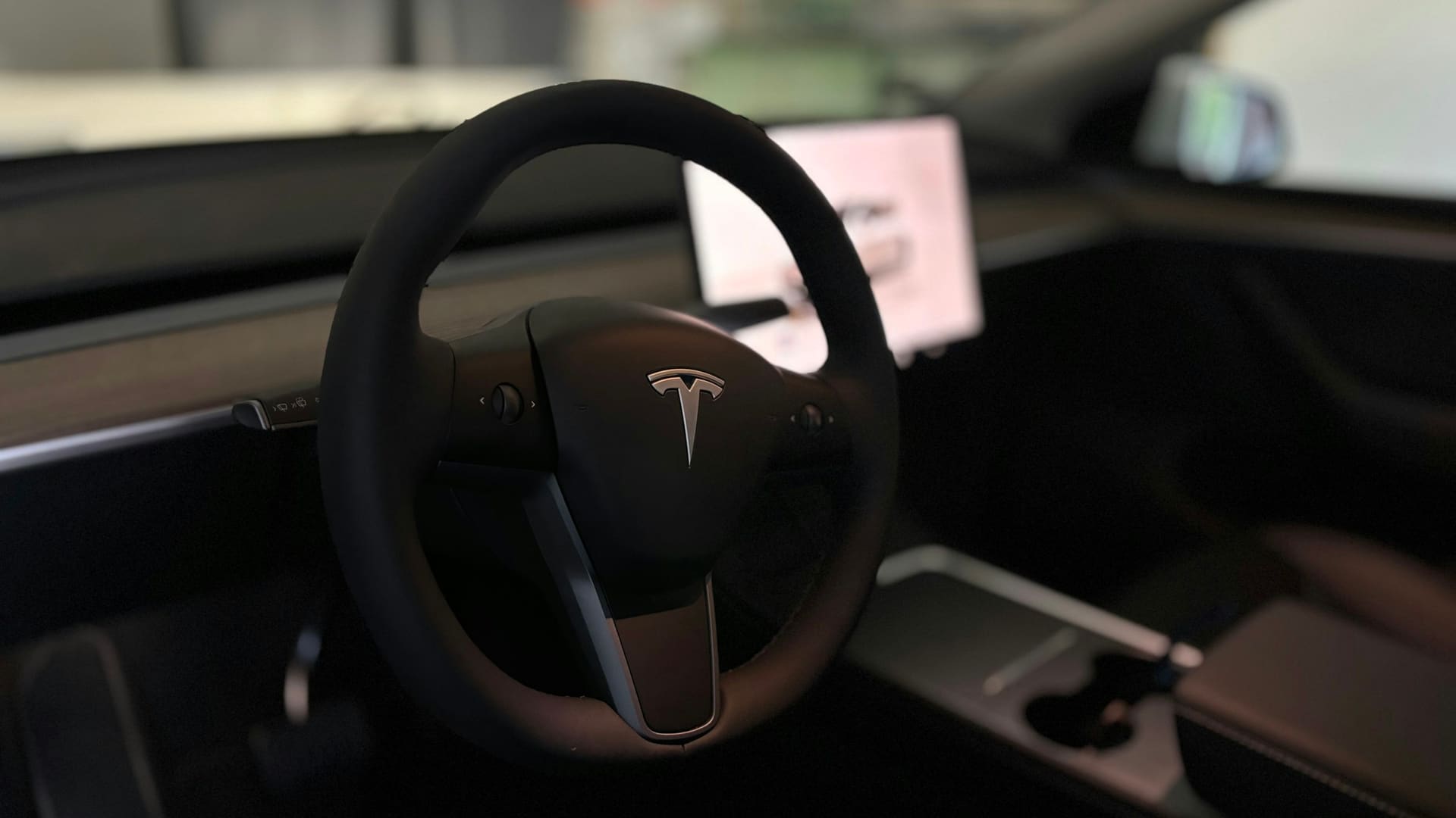 Interior of a Tesla Model Y Long Range showing the steering wheel, minimalist dashboard and center touchscreen