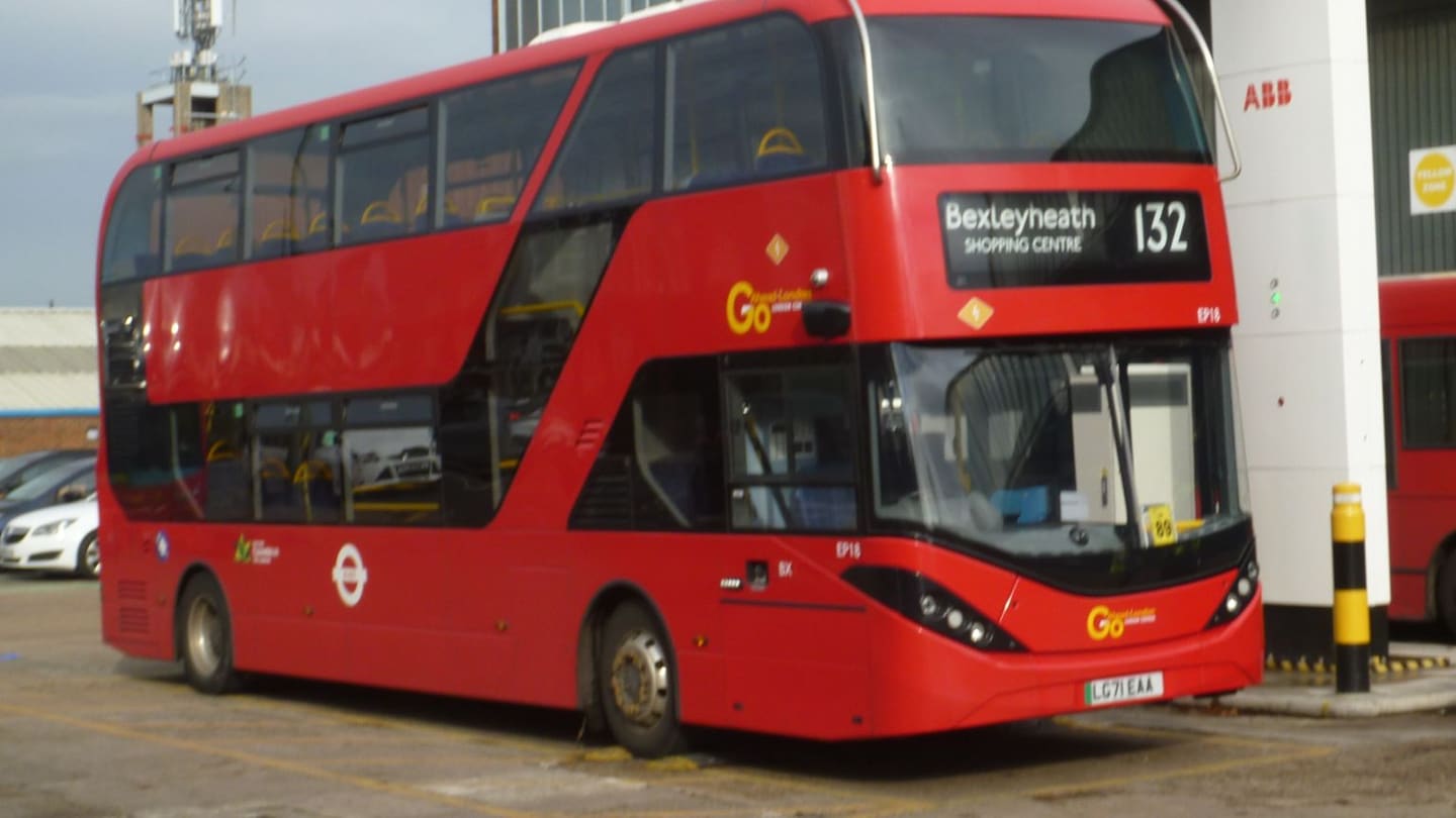 Electric double-deck bus positioned under overhead pantograph charging arm