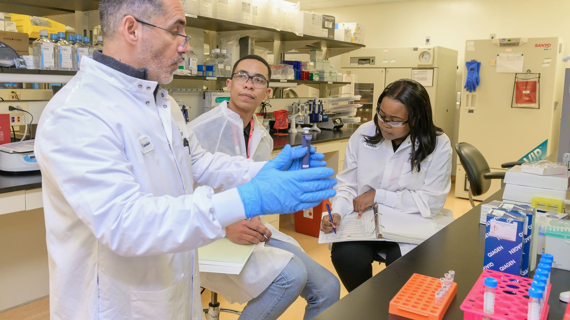 Group of researchers collaborating in a life sciences laboratory examining research samples