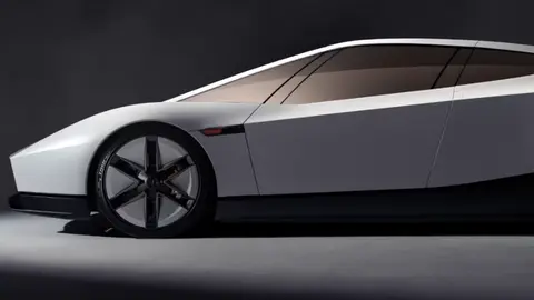 Side view of the new white Tesla Roadster, a low angular coupe with a long glass roof